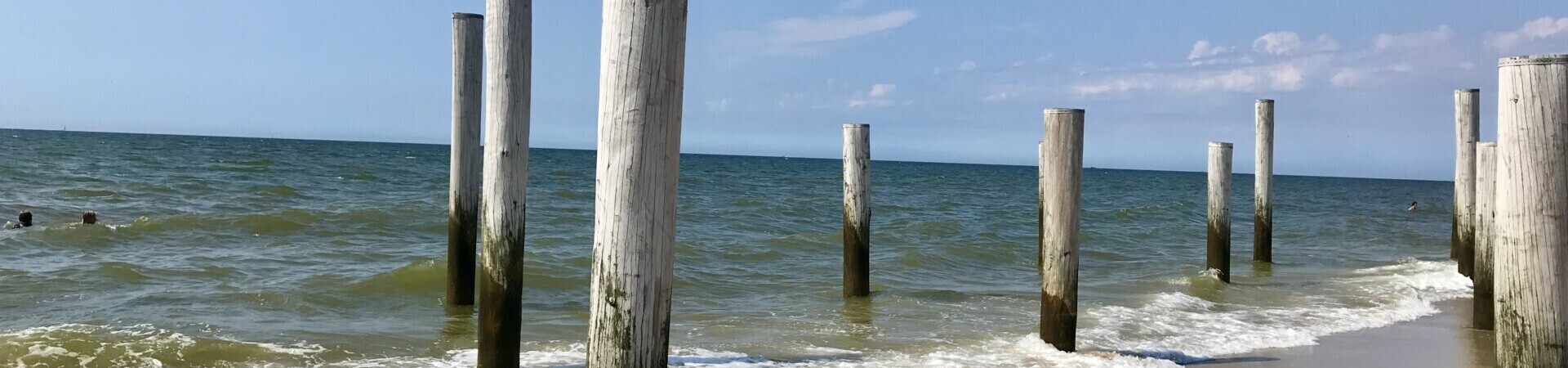 strand met houten palen